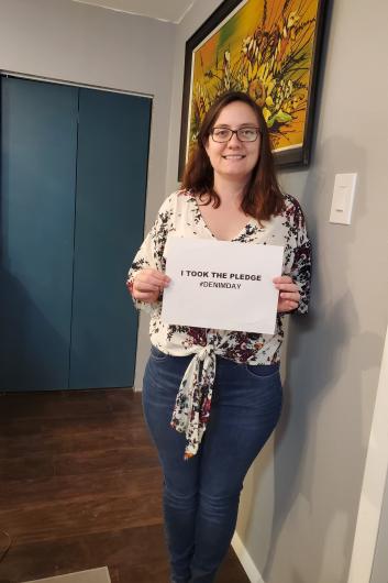 Robin Milne from NPS holding the I took the Pledge #DenimDay sign. 
