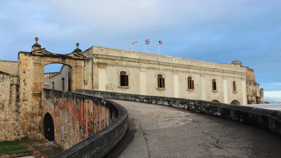 A wide stone ramp leads up to the ornate white walls of an old fort.