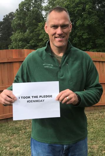 Scott Larson from NPS, holding the I took the Pledge #DenimDay sign. 
