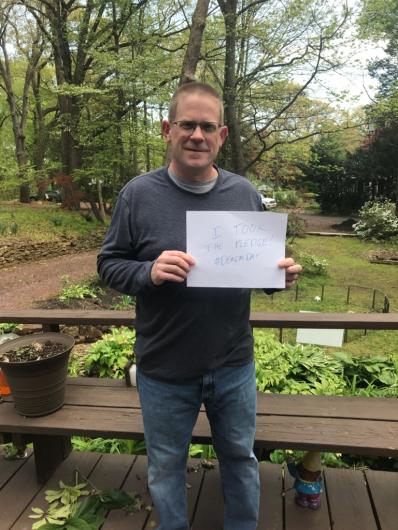 Sloan Farrell from OCR outside holding the I Took the Pledge #DenimDay sign.