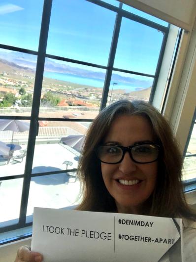 Susan Mical from USBR standing by window with the I took the Pledge #DenimDay sign. 
