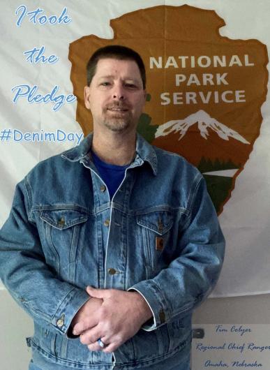 Tim Colyer from NPS holding the I took the Pledge #DenimDay sign