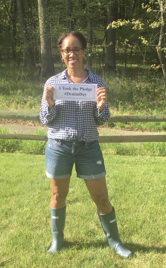 Tanisha Edmonds from OCR, outside holding the I took the Pledge #DenimDay sign.