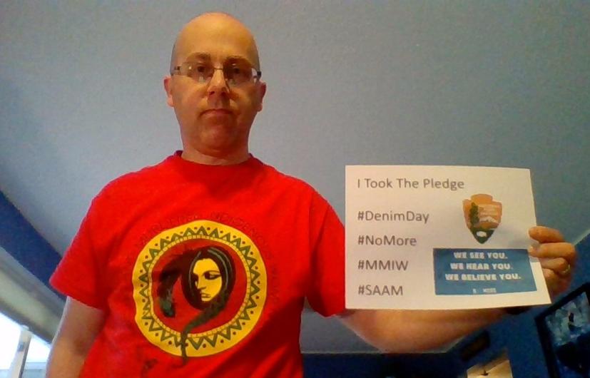 Theodore Gostomski from NPS holding the I took the Pledge #DenimDay sign. 
