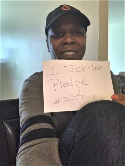 Tina Hall from OCR holding the I took the Pledge #DenimDay sign. 