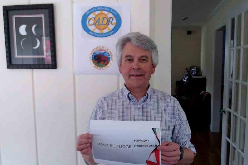 William Hall from CADR holding the I took the Pledge #DenimDay sign.