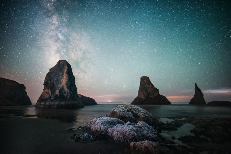 Stars light up a green, blue sky at Oregon Islands National Wildlife Refuge.