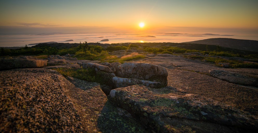 Pastel colors highlight the sky with the landscape in the foreground at sunrise.