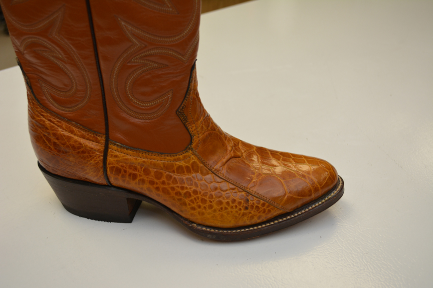 A cowboy boot made of turtle skin with intricate design