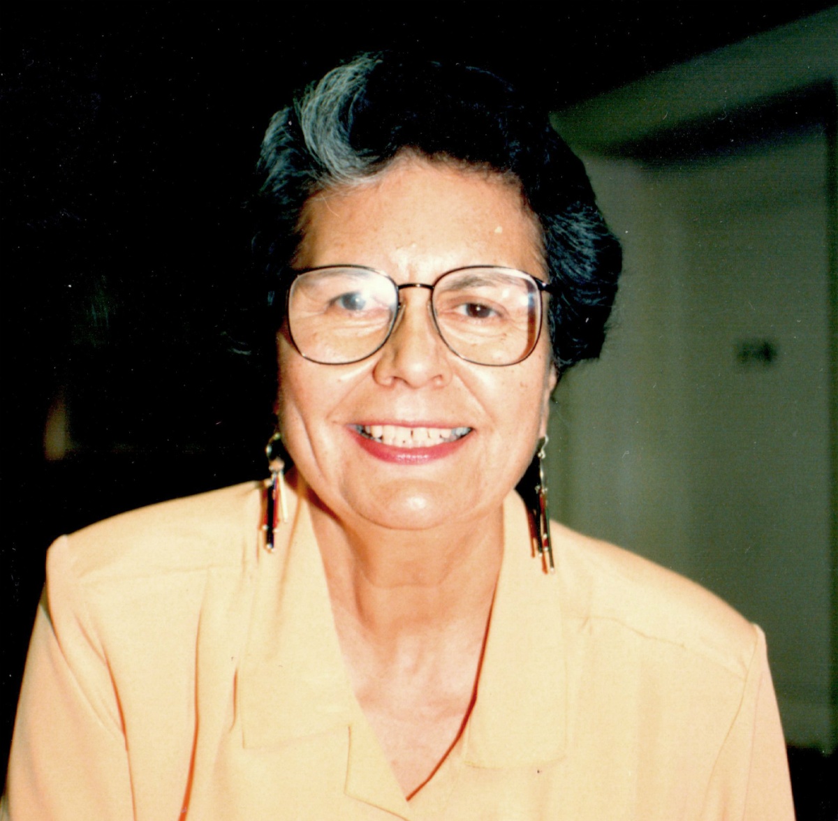 Ada Deer - a woman with dark hair and glasses - smiles at the camera.