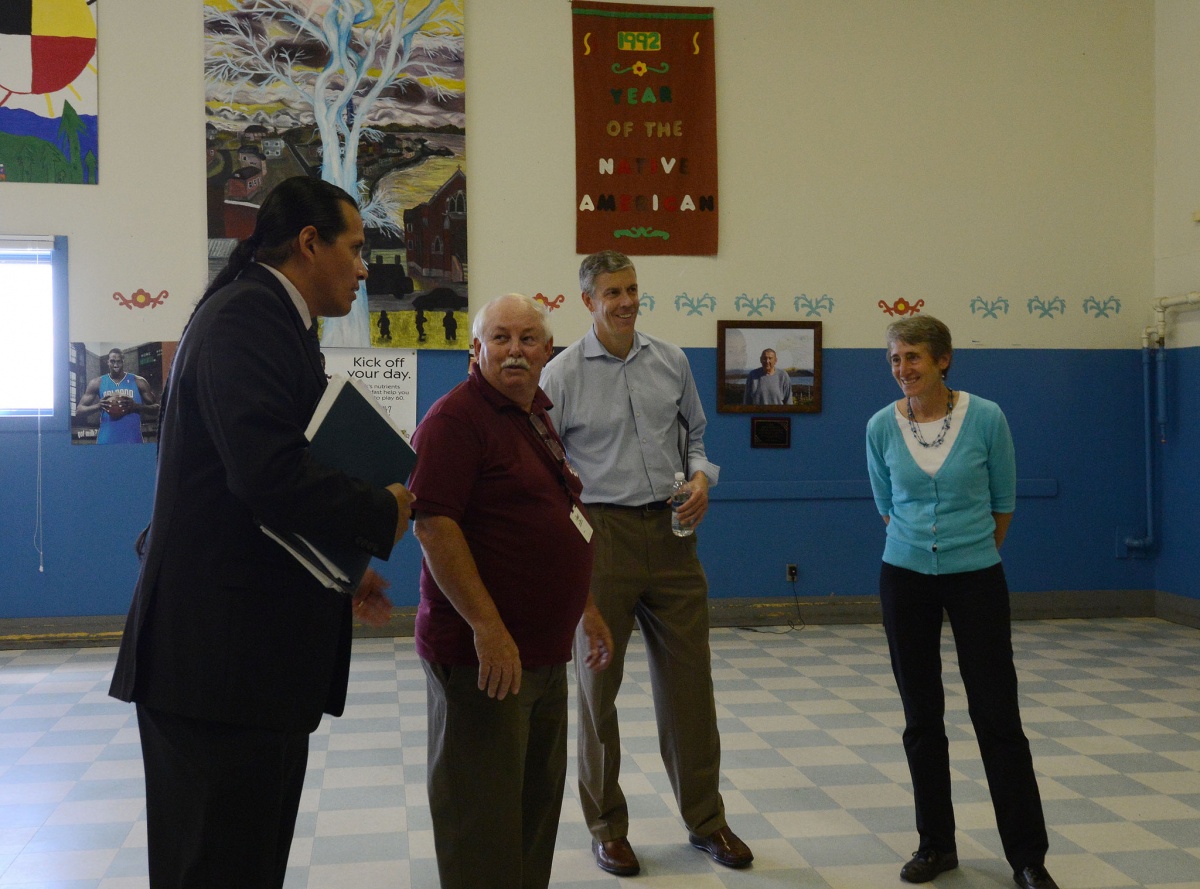 Secretary Jewell stands in a school gym with school officials.