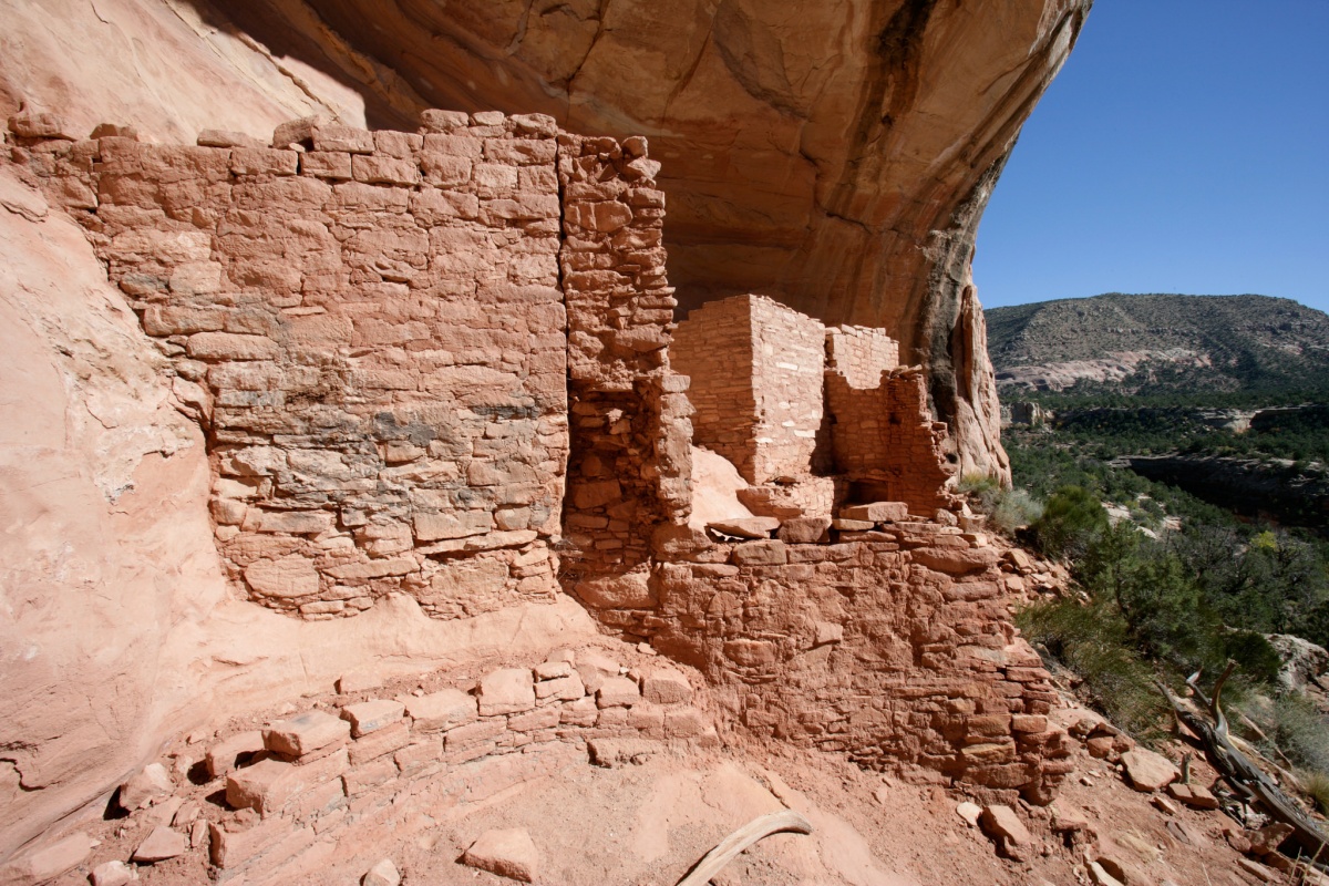 Red cliffs and bricks sit above open green and brown land