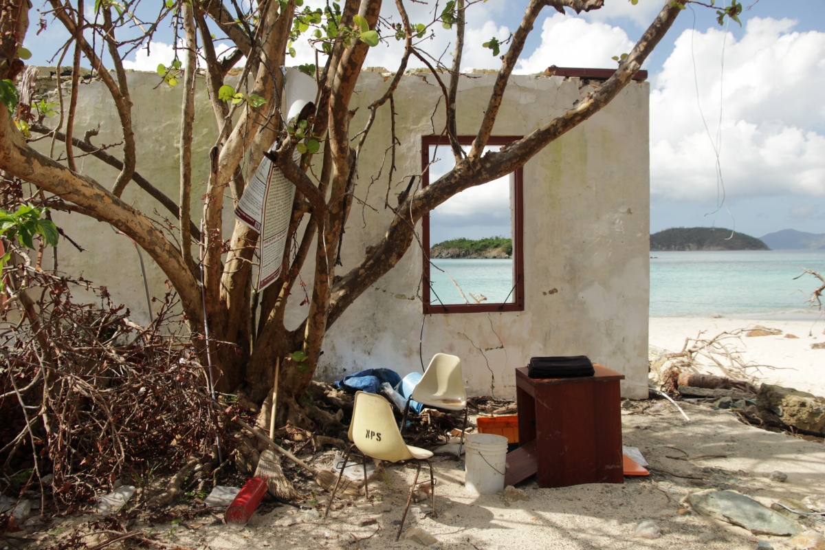 The ruins of a demolished building stand on a beach.