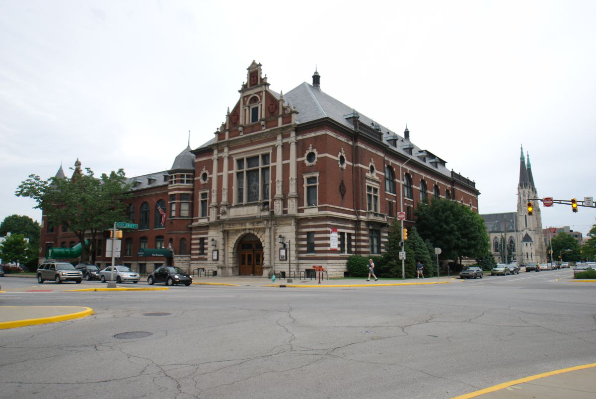 A grand red and white building stands next to the road. 