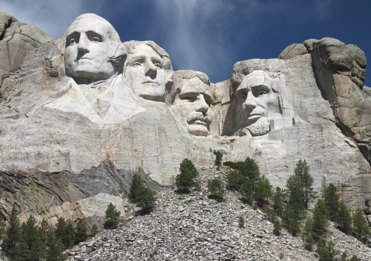 The four massive heads sculpted into Mount Rushmore look out under a pretty blue sky.