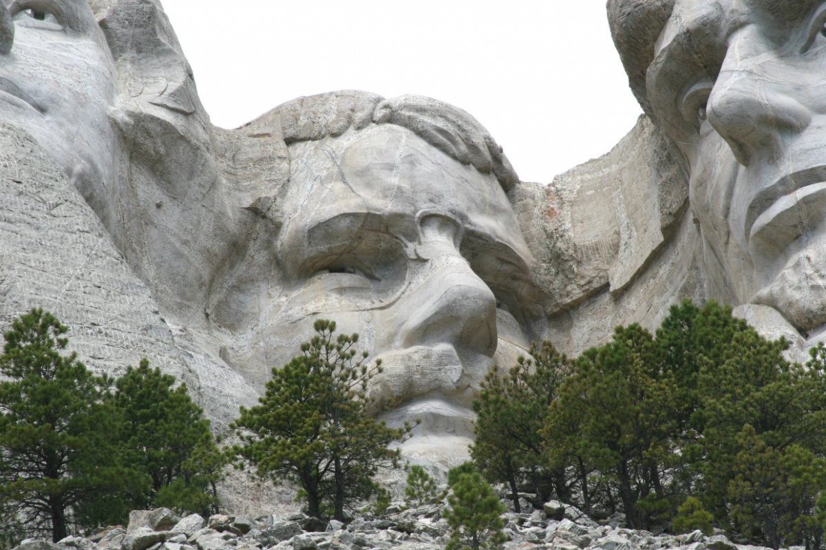 The massive face of Theodore Roosevelt is carved into the stone wall of Mount Rushmore.