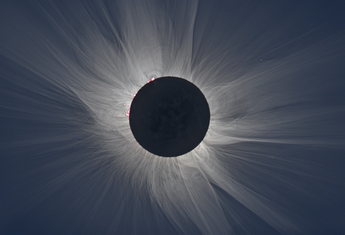 The large black circle of the moon blocks the sun as light streams around its edges.