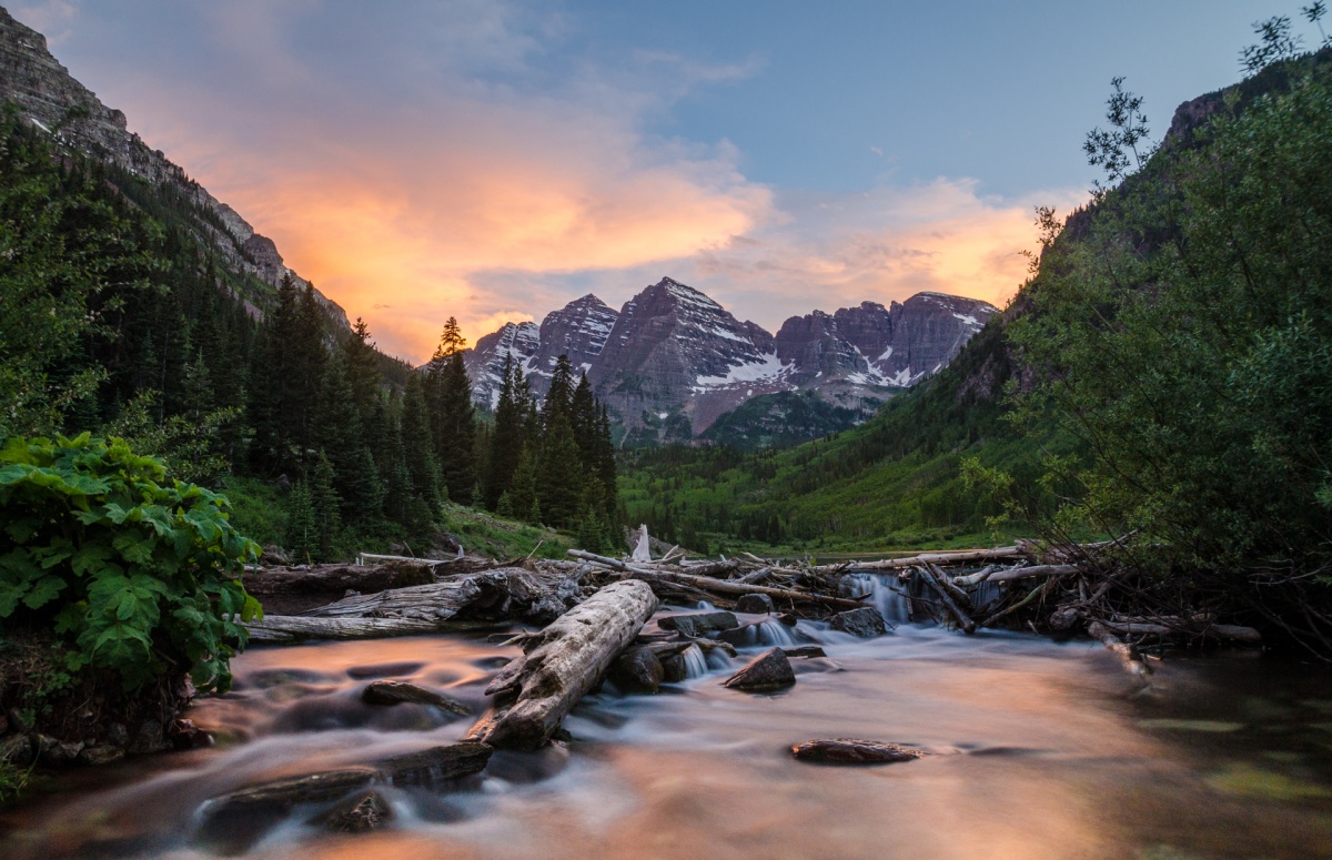 snow-covered peaks in a lush green valley