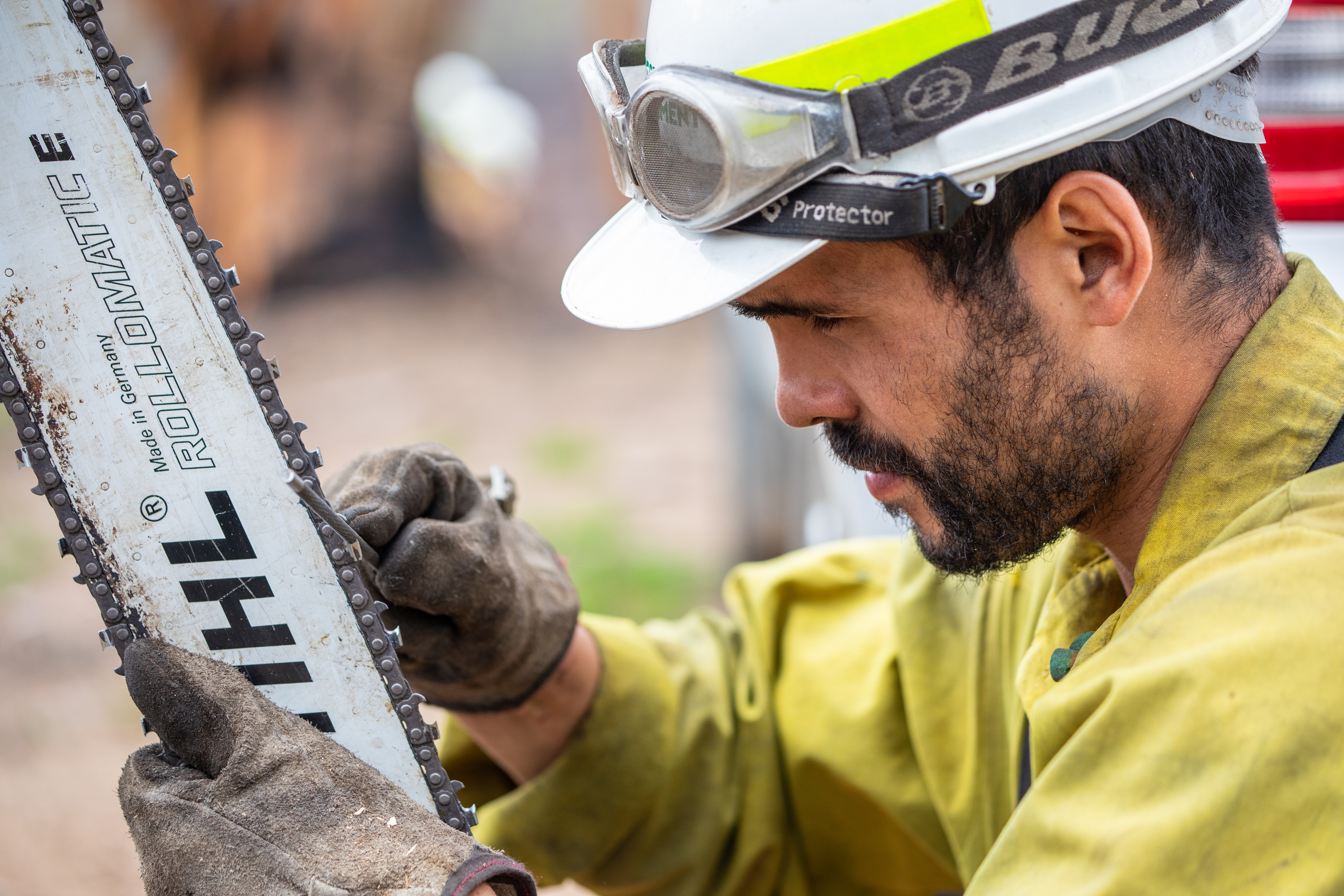 Photo by Neal Herbert, Department of the Interior. Firefighter maintains a chainsaw.